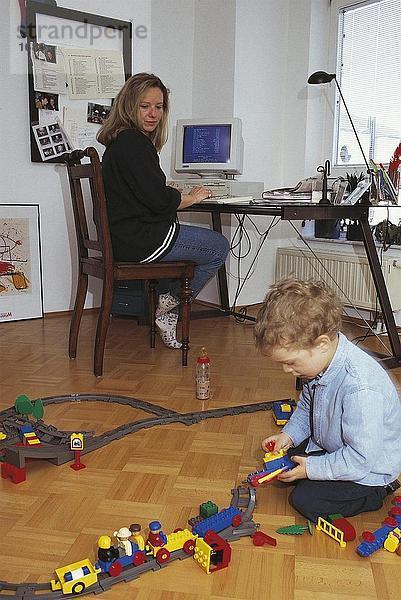 Frau blickt auf ihr Sohn spielen mit Spielzeug  Deutschland
