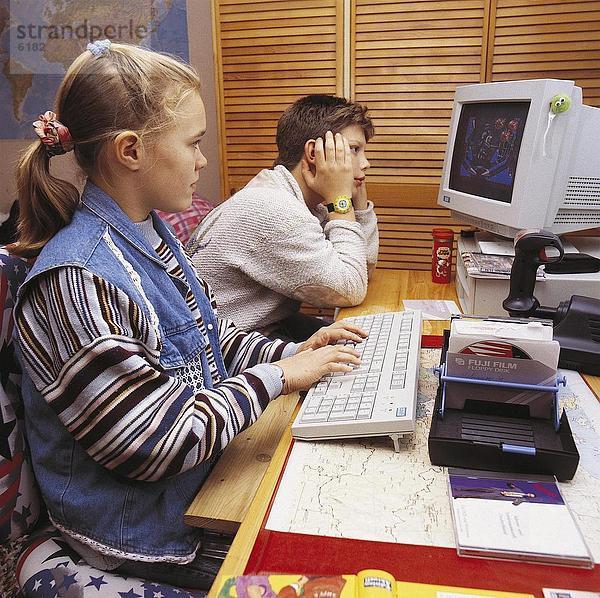 Seitenansicht Mädchen auf Computer mit jungen sitzend neben ihr Spiel spielt