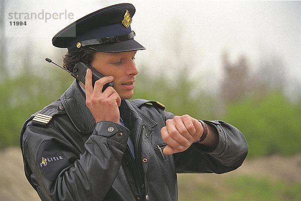 Nahaufnahme des Polizisten sprechen auf Handy  Niederlande