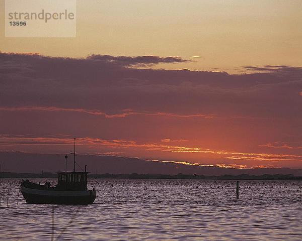 Silhouette eines Schiffes in Wasser des Sees in der Dämmerung  Redentin  Mecklenburg-Vorpommern Deutschland