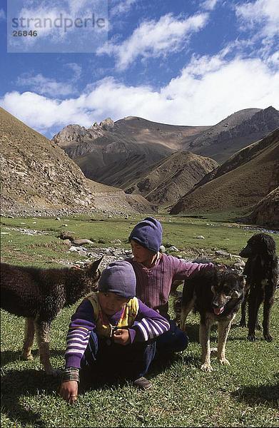 Kinder hocken Landschaft mit Hund  Kirgistan