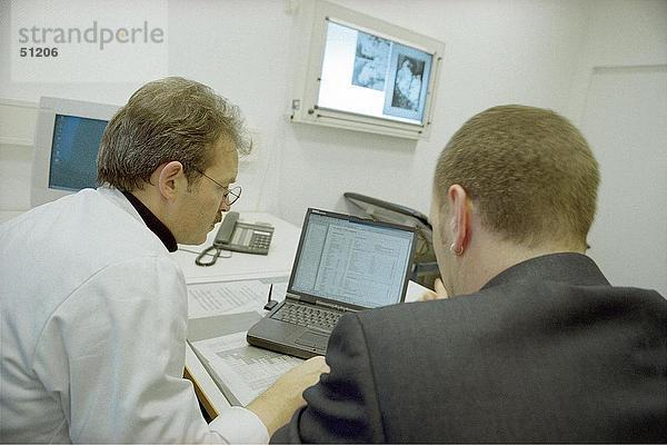 Rückansicht von zwei Ärzten mit laptop