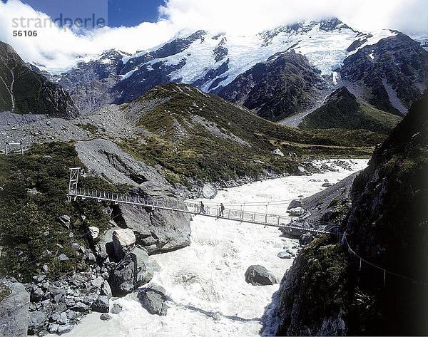 Erhöhte Ansicht von zwei Personen über eine Brücke über einen Fluss  Mt. Cook-Nationalpark  Hooker Tal  Neuseeland