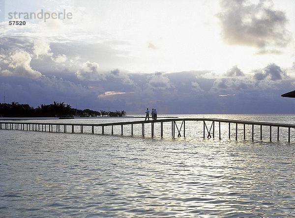 Drei Menschen stehen auf einer Brücke  Malediven