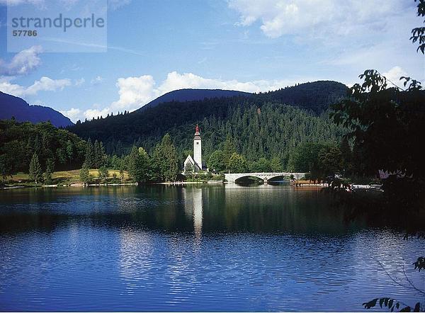 Bogenbrücke in der Nähe einer Kirche durch den Fluss  Nationalpark Triglav  See Bohinj  Slowenien