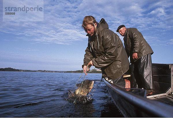 Woman fishing in sea  Chiemsee  Munich  Bavaria  Germany