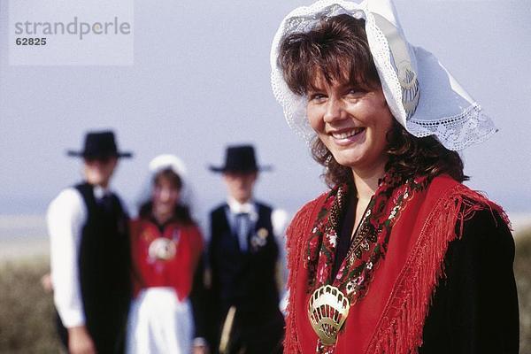 Junge Frau lächelnd in traditionellen Kleidern  East Watteninsel  Niedersachsen  Deutschland