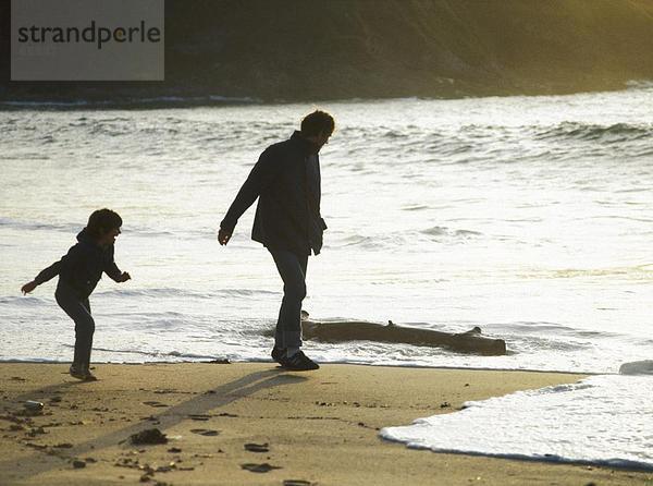 Mann und seine Tochter Wandern am Strand