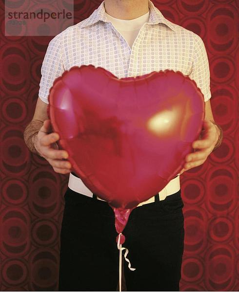 10542760  Ballon  halten  Herzen  Herzform  Körper-Detail  Liebe  Luft Ballon  Mann  rot  Symbol