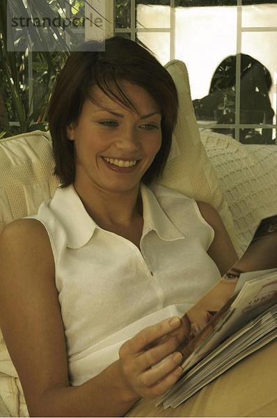 10642238  Frau  innerhalb  lachen  lesen lesestoff  Magazin  nehmen Sie es einfach  zu entspannen  Aufenthaltsräume  Magazin Sit  Sofa