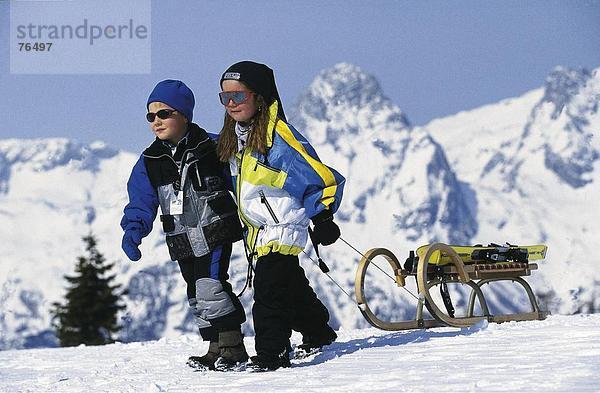 10644433  alpine  Alpen  Berge  Freizeit  junge  Kind  Kinder  junge  Mädchen  Schlitten  Schlitten  Rodel  Schlitten  Schlitten  Pulli