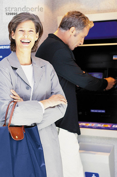 Mann und Frau bei Geldautomaten