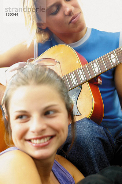 Teenager Junge und Mädchen spielen Gitarre