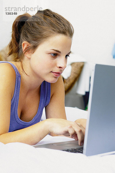 Teenager-Mädchen auf Laptop-Computer
