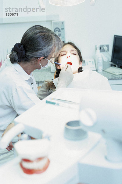 Mädchen wird vom Zahnarzt untersucht