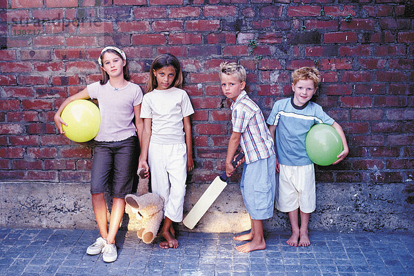 Portrait von Jungen und Mädchen mit ihren Spielsachen