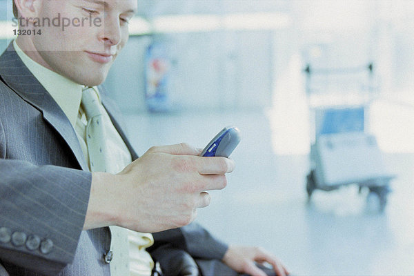 Geschäftsmann mit Handy am Flughafen