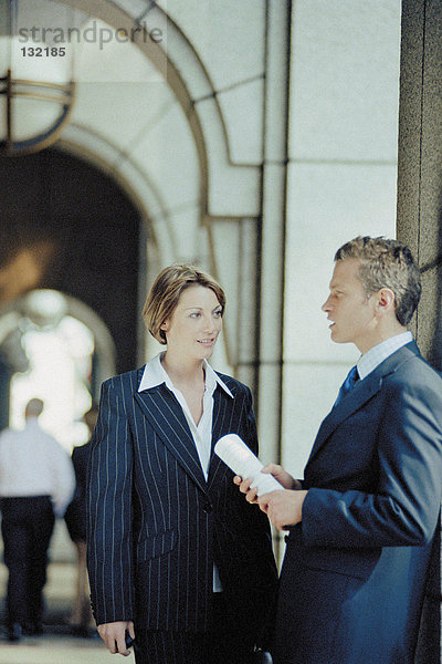 Geschäftsmann und Geschäftsfrau im Gespräch außerhalb des Büros