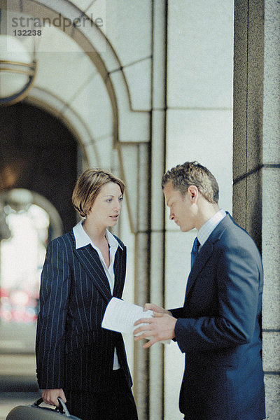 Geschäftsmann und Geschäftsfrau im Gespräch außerhalb des Büros