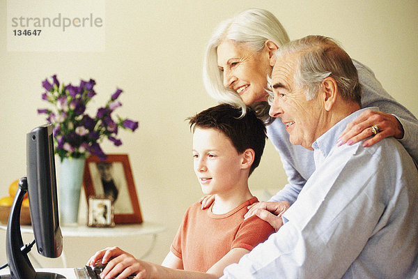 Großeltern und Enkel am Computer