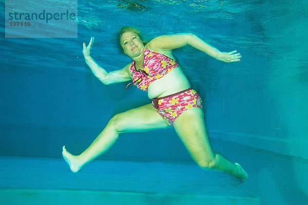 Eine Frau tanzt unter Wasser