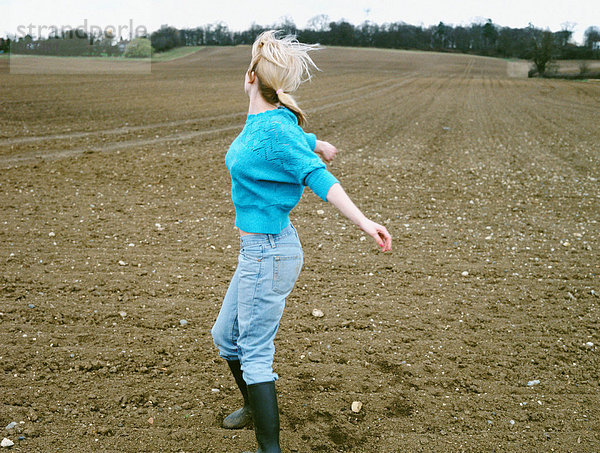 Frau tanzt auf einem Feld