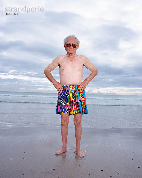 Ein reifer Mann in hellen Shorts am Strand
