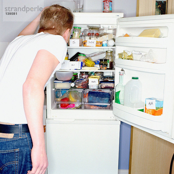 Mann sucht im Kühlschrank