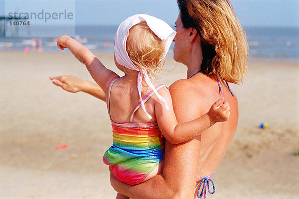 Frau mit Kleinkind am Strand