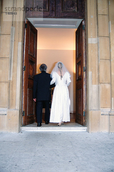 Die Braut geht mit ihrem Vater in die Kirche.