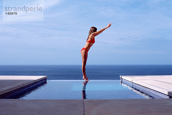 Junge Frau am Schwimmbad am Meer