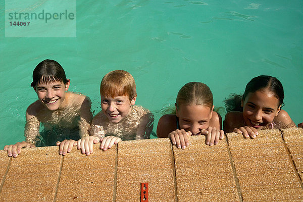 Kinder  die am Pool lächeln