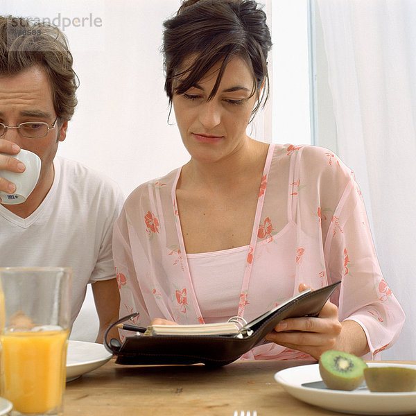 Paar mit Tagebuch beim Frühstück