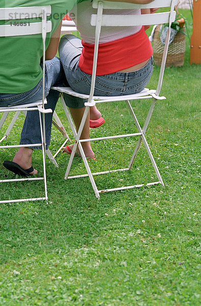 Paar auf Stühlen im Garten
