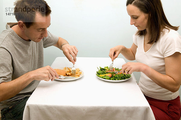 Paar mit kontrastierenden Mahlzeiten