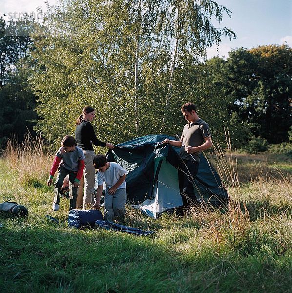Familie baut ein Zelt auf