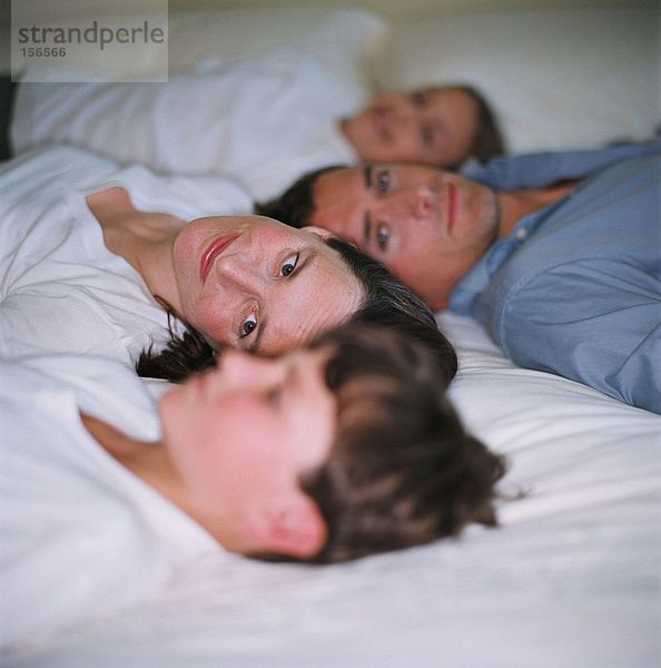 Familie entspannt auf dem Bett
