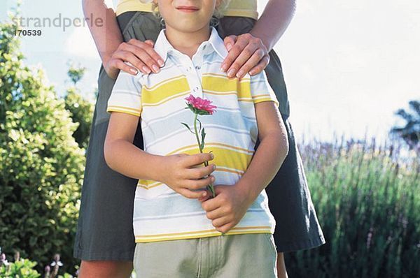 Mutter mit Sohn hält Blume