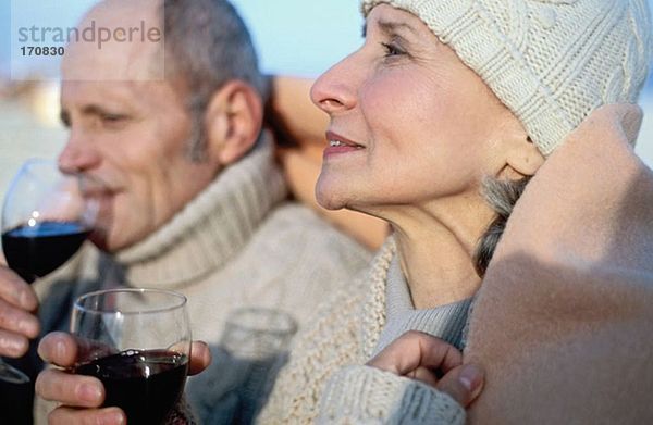 Seniorenpaar trinkt Wein in Decke