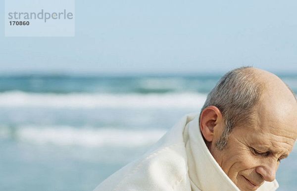 Senior Mann am Strand mit Blick nach unten