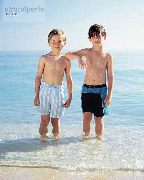 Zwei Jungen  die im Meer stehen.