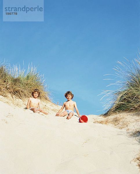 Zwillingsjungen in einer Sanddüne