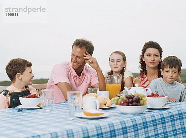 Familie beim Frühstück im Freien