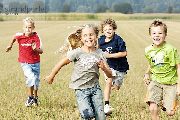 Kinder laufen über Feld