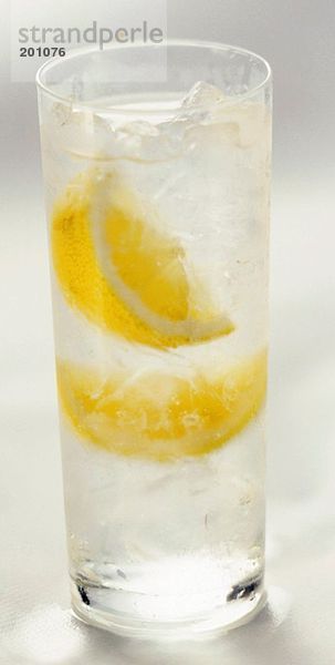 Glas Wasser mit Eiswürfeln und Zitronen