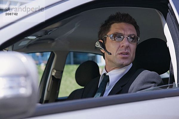 Geschäftsmann im Auto mit Headset