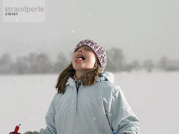 Mädchen beim Schneefang auf der Zunge