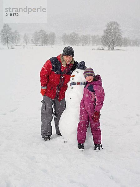 Vater und Tochter mit Schneemann