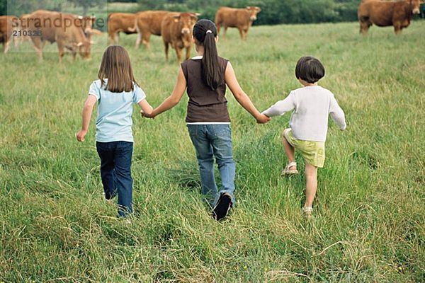 Mädchen hüpfen auf Kühe zu