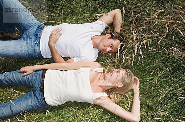 Junges Paar auf einem Feld liegend